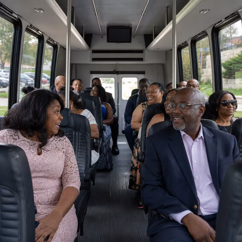 Group boarding a white charter bus for Private Event Transportation transportation in Tucson