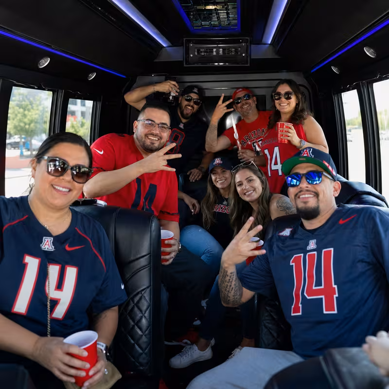 Group boarding a white charter bus for Sporting Event Transportation transportation in Tucson