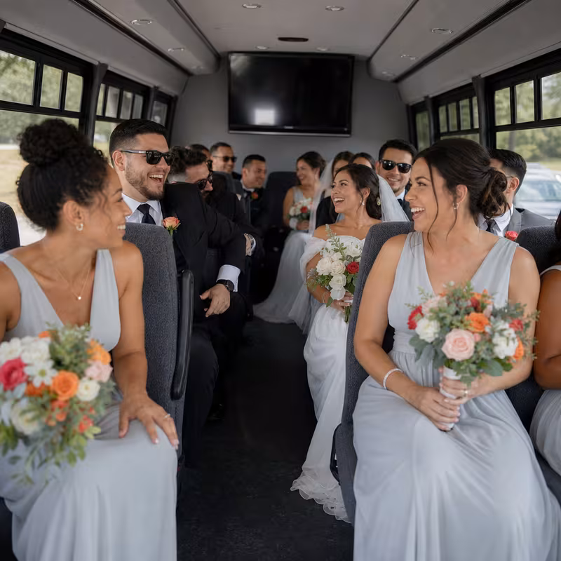 Group boarding a white charter bus for Wedding Transportation transportation in Tucson